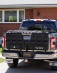 Black pickup truck with 'CACHE' branding parked in front of a house.