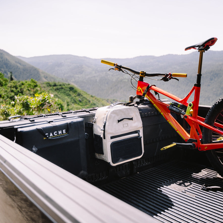 Red bicycle on a truck bed with mountains in the background