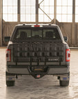 Back view of a truck with a Cache bed cover in an indoor setting