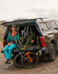 Pickup truck with padded tailgate and mountain bikes parked on a dirt road.