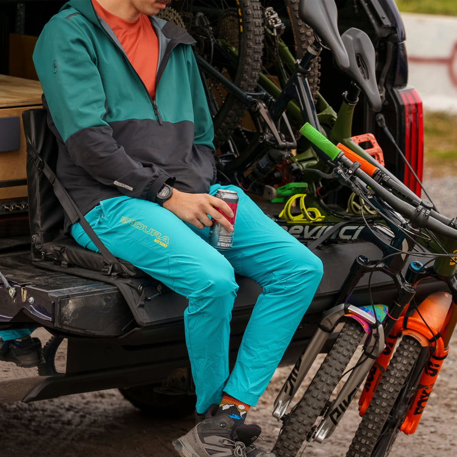 Truck equipped with a black tailgate pad carrying two mountain bikes in a rural setting