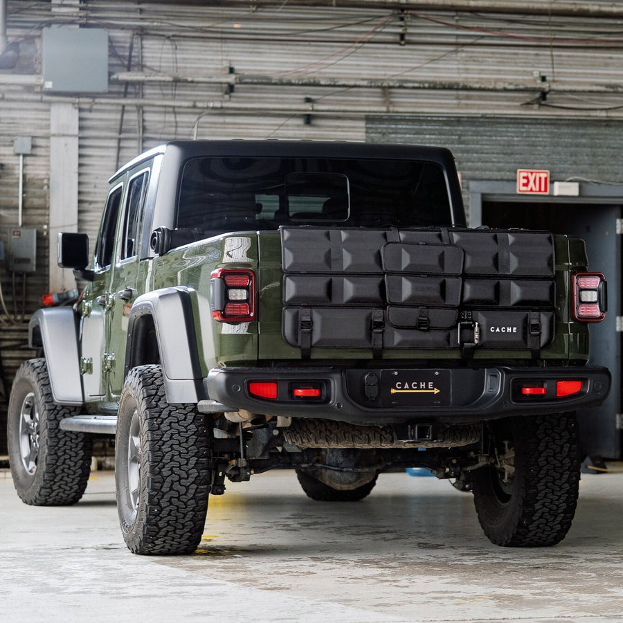 Green off-road vehicle with a toolbox attached to the back in an industrial setting.